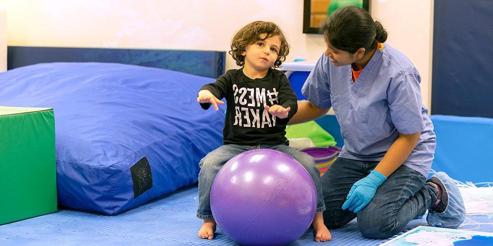 Nurse with child on bounce ball