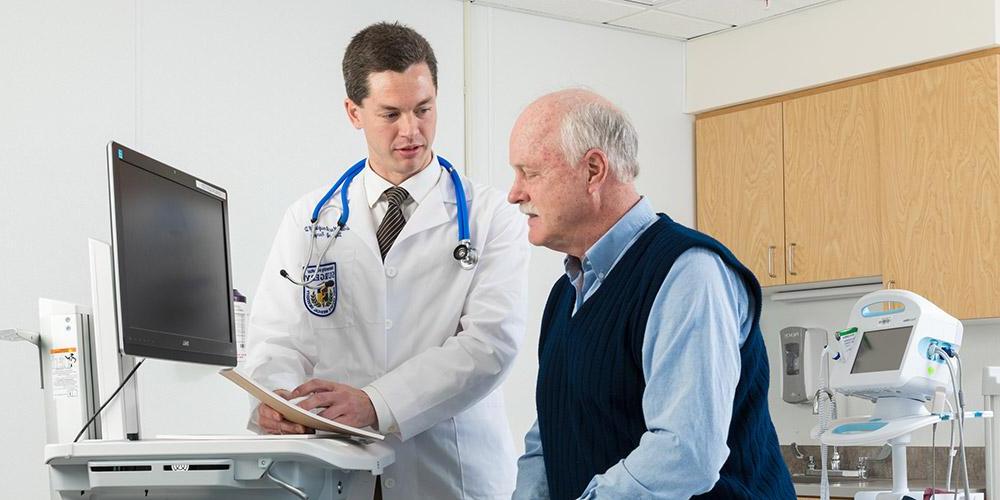 Dr. Maclaughlin with patient in his office.